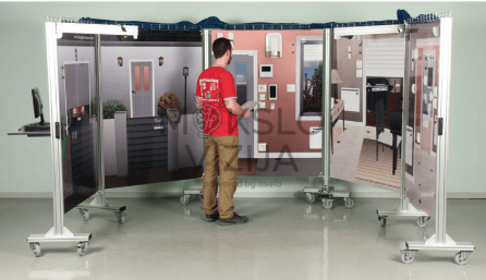KNX technologijos išmaniojo namo simuliacijos mokymo stendas su sujungtais moduliais ant mobilių rėmų