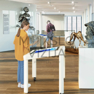 Interaktyvus informacinis stalas muziejuje, naudojamas edukacijai ir ekspozicijų turinio peržiūrai lietimui jautriame ekrane.