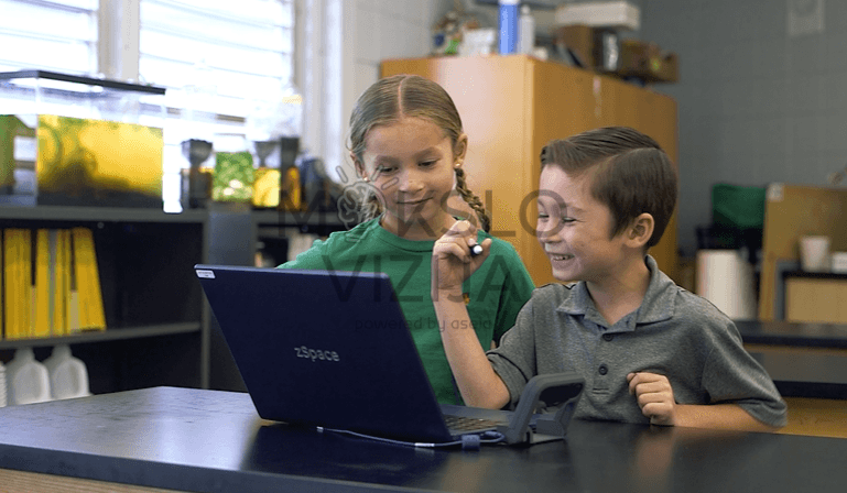 Modernus 3D kompiuteris mokyklai – stilingas baltas įrenginys su kamera ir planšetiniu pieštuku, skirtas virtualių mokymo modelių peržiūrai.