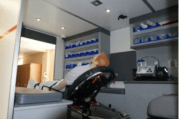 Realistiška greitosios pagalbos simuliacinė kabina – mokymo aplinka su medicinos įranga ir apšvietimu.