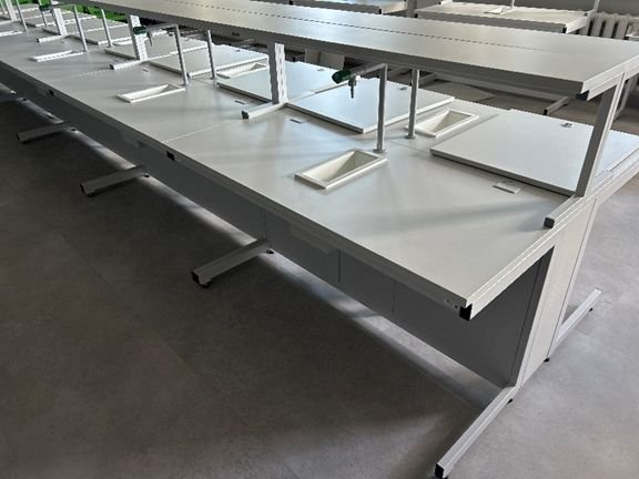 Laboratorinis stalas su kriaukle, čiaupu, viršutine lentyna ir metaliniu C formos rėmu.