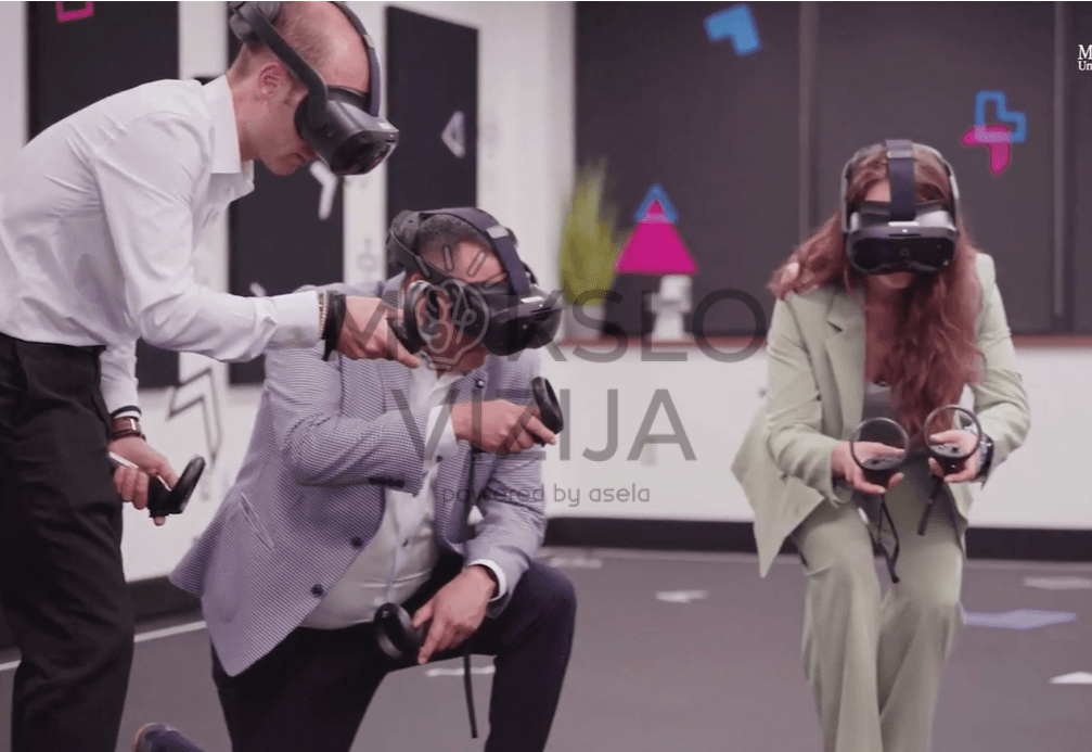 Žmonės realiame pasaulyje naudojasi VR įranga, kad atliktų praktinius mokymus.