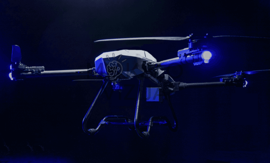 ALT text: Pramoninis dronas tamsiame fone su LED apšvietimu, paruoštas darbui sudėtingomis sąlygomis ir stebėsenai.