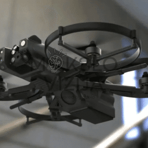 Kompaktiškas taktinis dronas su apsaugotais rotoriais ir integruota kamera skrenda patalpose prie laiptų.