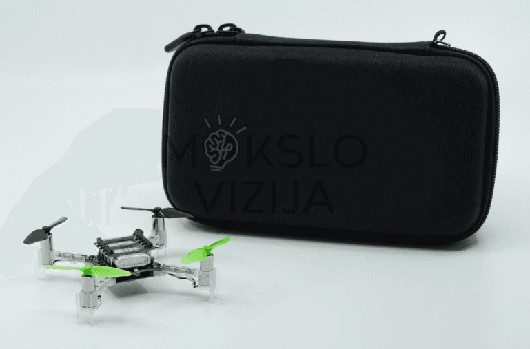 Edukacinis mini dronas su propeleriais padėtas šalia tvirto transportavimo dėklo, skirto saugiam laikymui ir pervežimui.