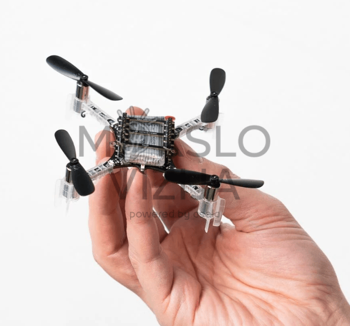 Žmogaus rankoje laikomas labai mažas edukacinis dronas su keturiais propeleriais ir lengva konstrukcija.