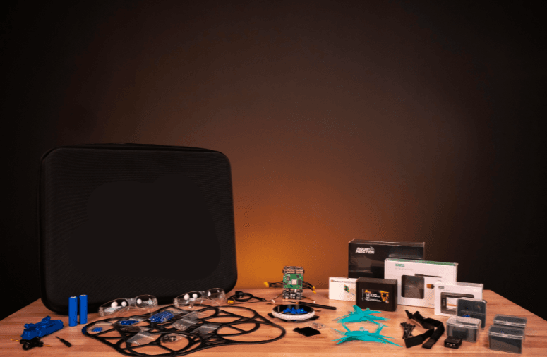 Autonominio drono mokymo komplektas su dėklu, komponentais, baterijomis ir priedais ant stalo