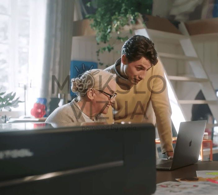 žmonės prie kompiuterio valdo xTool P2S lazerines graviravimo ir pjovimo stakles darbo aplinkoje