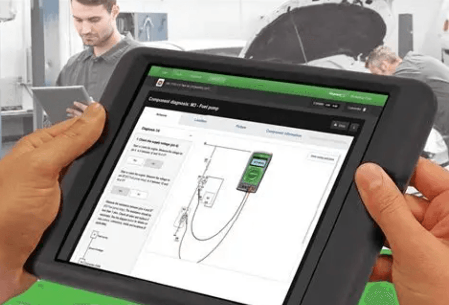 Planšetė autoservise su atidaryta HaynesPro sistema ir elektros schemos vaizdu.