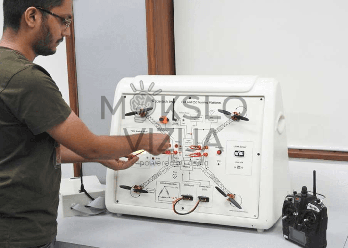 FCB ir ESC dronų mokymo platforma su integruotais propeleriais, elektronikos testavimo taškais, maitinimo moduliu ir nuotolinio valdymo pultu, skirta profesiniam dronų technologijų mokymui.