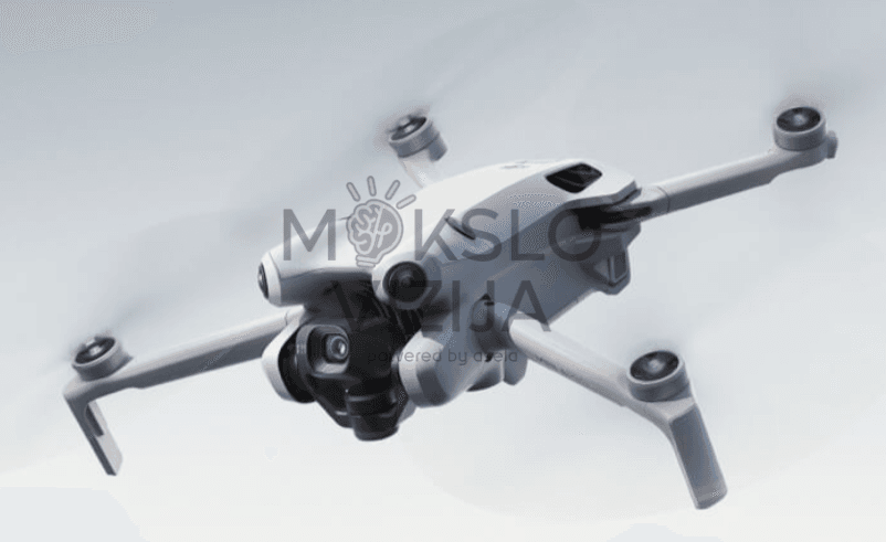 DJI Mini 4 Pro dronas skrydžio metu su integruota kamera ir kliūčių aptikimo sistema, skirtas profesionaliam filmavimui ir fotografijai.