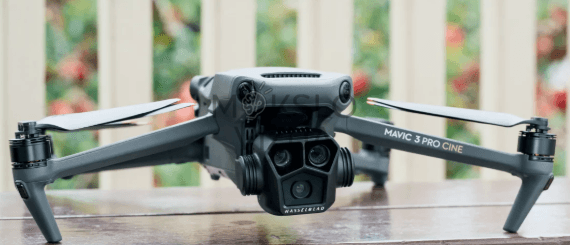 DJI Mavic 3 Pro dronas skrydžio metu virš kalnų kraštovaizdžio, skirtas profesionaliam filmavimui ir inspekcijoms.