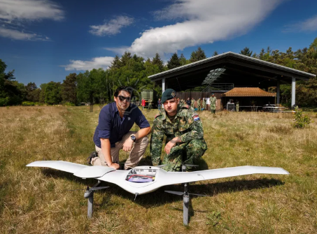 DeltaQuad Evo fiksuoto sparno dronas ant žemės su operatoriais, skirtas profesionalioms kartografavimo ir stebėjimo misijoms.