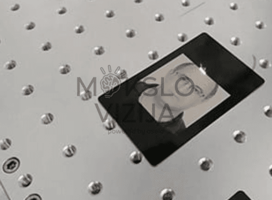 Pluoštinio lazerio graviravimo rezultatas ant metalinės plokštelės su detaliu vaizdo išgraviravimu.