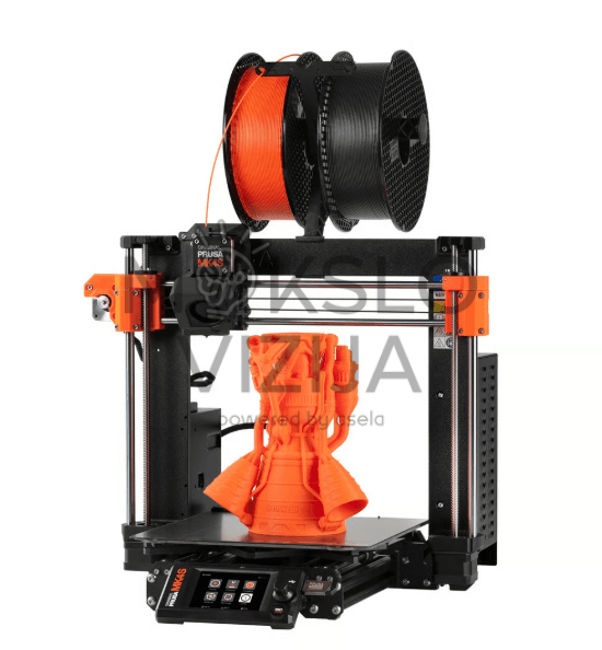 Original Prusa MK4S 3D spausdintuvas su oranžine ir juoda plastiko gija viršuje bei oranžiniu 3D spausdintu modeliu ant kaitinamos platformos.