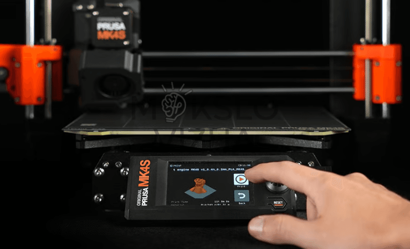 Original Prusa MK4S 3D spausdintuvo valdymo skydelis su jutikliniu ekranu, kuriame rodoma spausdinimo informacija, o pirštas liečia ekrano meniu.