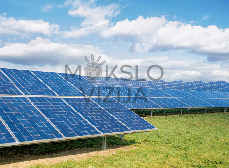 Saulės elektrinės moduliai lauke išdėstyti eilėmis ant konstrukcijų po atviru dangumi.