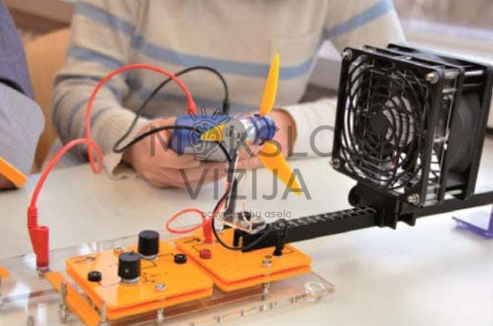 Mokomasis energijos konversijos bandymas su turbinos modeliu, ventiliatoriumi ir matavimo laidais laboratorijoje.