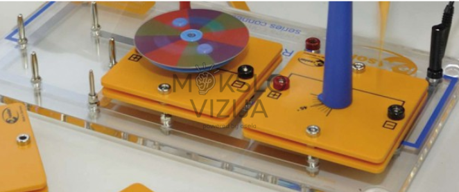 Vėjo turbinos mokomoji platforma su geltonais moduliais, spalvotu rotoriaus disku ir vertikaliu vėjo srauto elementu.