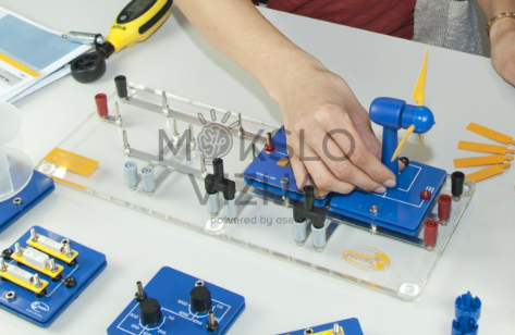 Vėjo turbinos mokomoji platforma su mėlynais moduliais, rotoriaus mentėmis ir matavimo įranga laboratoriniams eksperimentams.