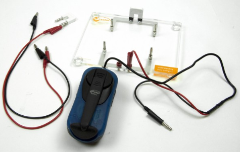 Rankinis generatorius su jungimo plokšte ir prijungtais laidais elektros eksperimentams.