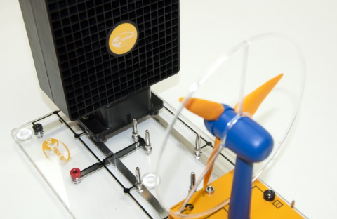 Saulės modulis ir vėjo turbinos modelis ant skaidrios eksperimentinės platformos atsinaujinančios energijos bandymams.