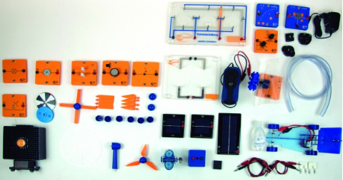 Saulės ir vėjo energijos mokymo rinkinys su moduliais, saulės elementais, laidais, vėjo turbinos detalėmis ir jungimo priedais ant balto fono.