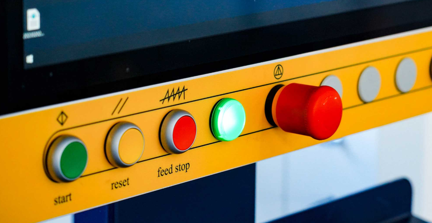 CNC staklių valdymo panelė su spalvotais mygtukais ir avarinio stabdymo jungikliu