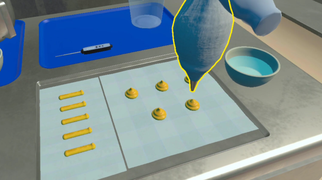 Virtualios realybės scena, kurioje konditerijos maišeliu formuojama tešla kepimo skardoje.