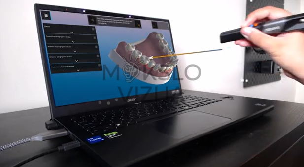 Nešiojamas kompiuteris su 3D dantų modeliu ekrane ir rankoje laikomu interaktyviu rašikliu odontologijos mokymams
