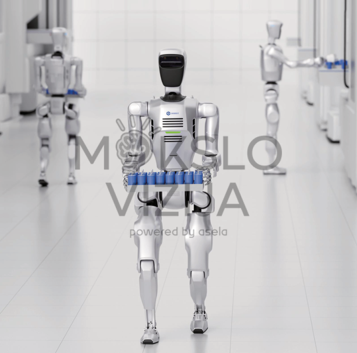 humanoidinis robotas eina per laboratoriją laikydamas dėžę su detalėmis