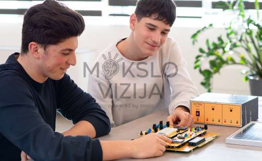 studentai dirba su elektronikos plokšte ir mokymosi moduliu praktiniams eksperimentams