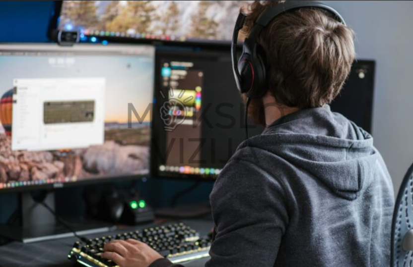 Studentas dirba su vėjo energetikos virtualios realybės mokymo programa kompiuterio darbo vietoje.