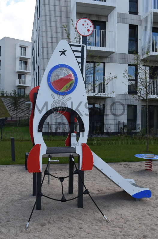 Kosmoso tematikos vaikų žaidimų aikštelė su raketos formos bokšteliu, čiuožykla, platforma ir laipiojimo tinklu.